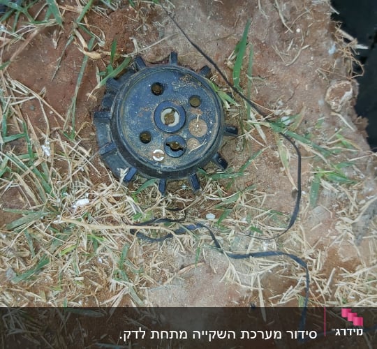 ראש ממטרה על אדמה עם דשא יבש